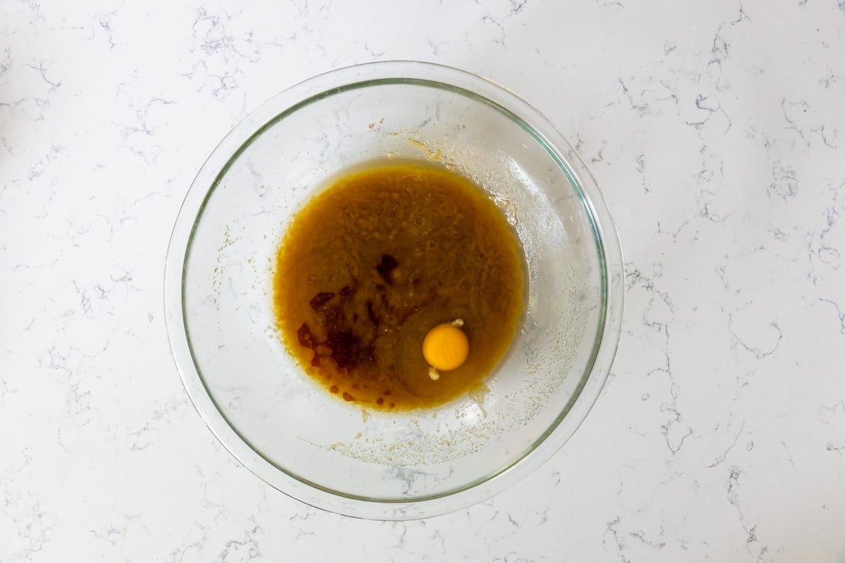 butter and sugar mixture in clear bowl with egg and vanilla